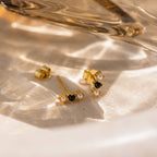 A chic pair of Tiny Onyx Pearl Bar Studs featuring gold bars with black and white stones.