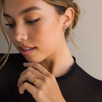 A woman wearing a black shirt and the elegant Onyx Pave Beaded Hoops, accented with gold and black onyx pavé.
