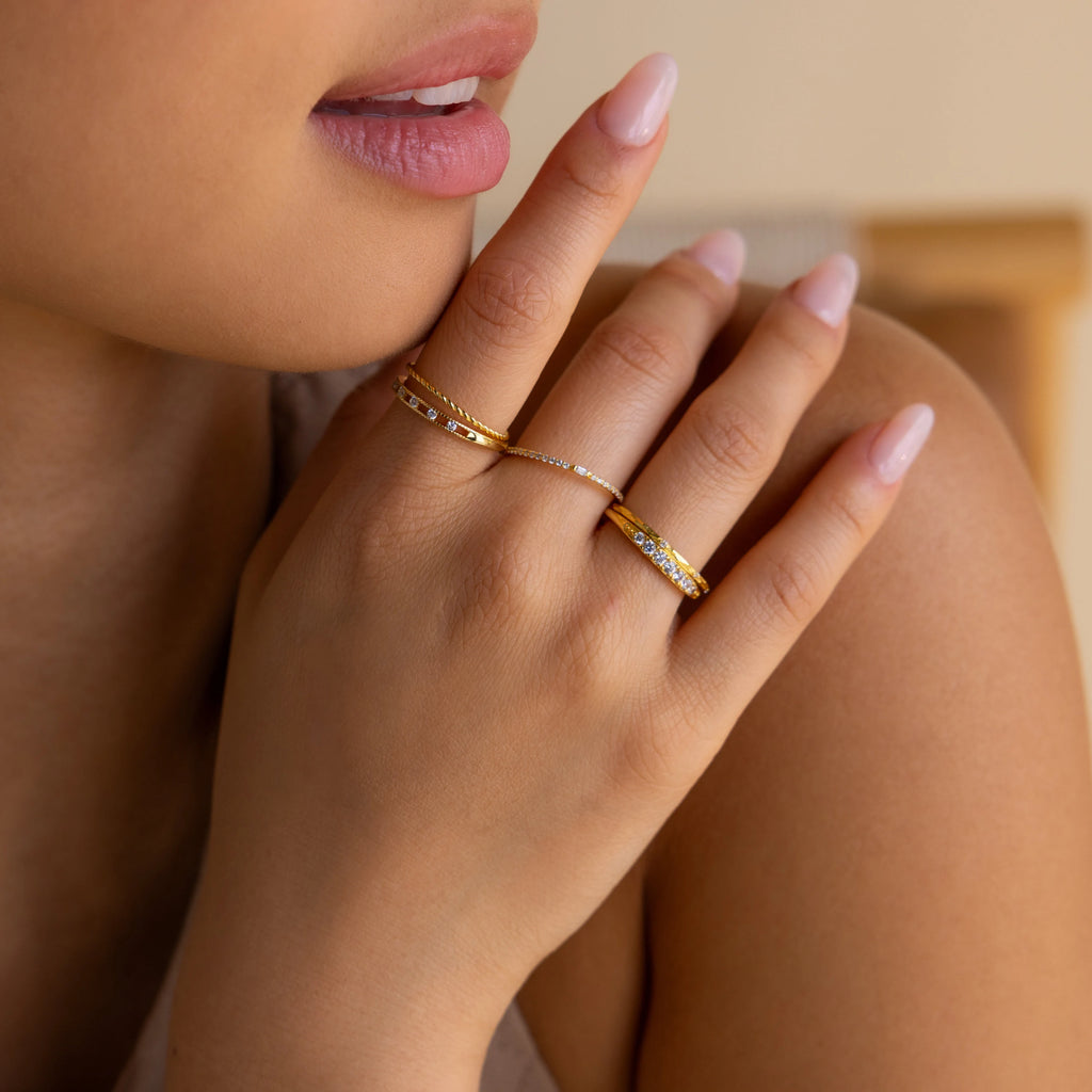 A close-up of a manicured hand near the lips, showcasing the Diamond Station Ring.