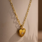 Diamond Ribbed Heart Necklace featuring a central gem on a gold chain, displayed against a neutral background—a stunning piece of vintage-inspired jewelry.