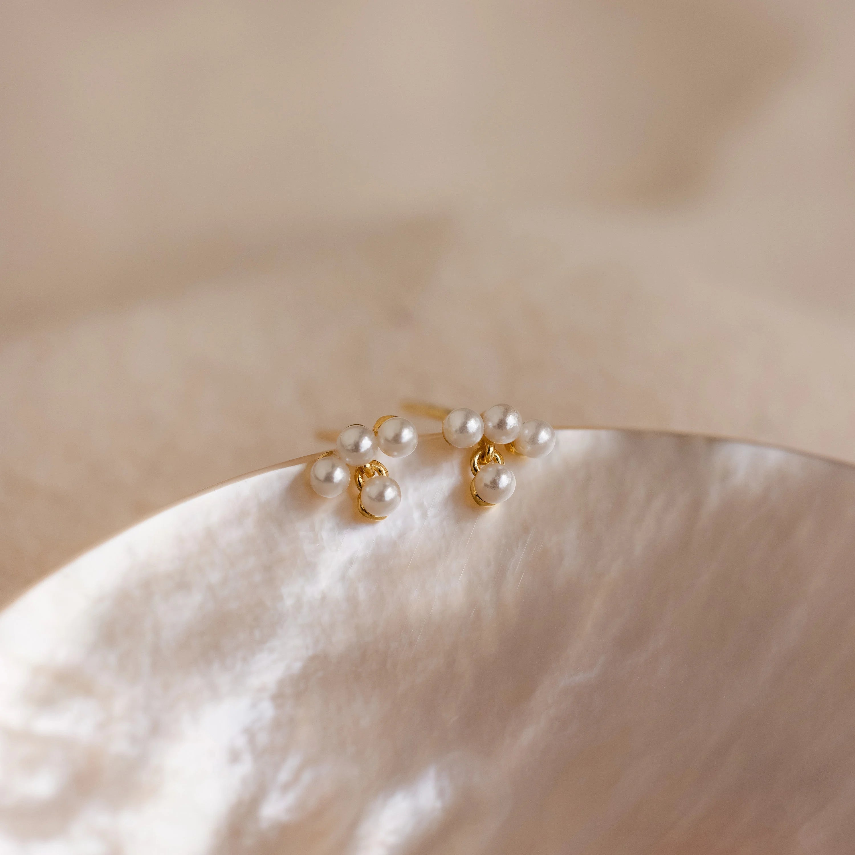 The Pearl Cluster Drop Studs feature elegant pearl clusters on a shell design, making them the perfect bridal earrings or a timeless wedding accessory.