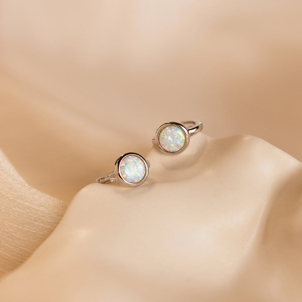 The Opal Signet Huggies are dainty hoop earrings that add a touch of elegance to any look.