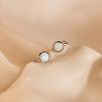 The Opal Signet Huggies are dainty hoop earrings that add a touch of elegance to any look.