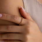A hand adorned with the Diamond Station Ring, accented by delicate diamonds, rests gently on a person's chest.