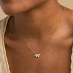 The White Opal Marquise Necklace, featuring gold floral design with white stones, adds a touch of timeless charm when elegantly worn on a woman's neck.