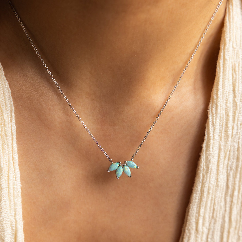 A close-up shows a person wearing the Turquoise Opal Marquise Necklace, featuring five turquoise stones set in silver around their neck.