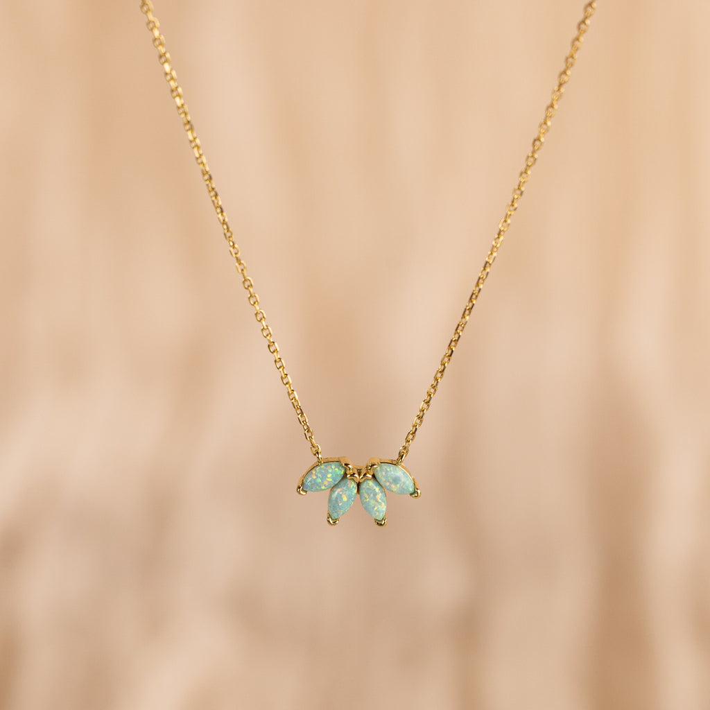 The Turquoise Opal Marquise Necklace features three small turquoise opal gemstones in a fan shape on a gold chain—a delicate necklace perfect for adding elegance to any look.