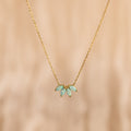 The Turquoise Opal Marquise Necklace features three small turquoise opal gemstones in a fan shape on a gold chain—a delicate necklace perfect for adding elegance to any look.