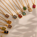 The North Star Garnet Necklace features a gold chain with a colorful rectangular crystal pendant and a delicate star design, perfectly capturing sunlight.