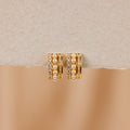 Diamond Pearl Stacked Hoops featuring rows of pearls and sparkling crystals, ideal for vintage wedding looks, showcased on a textured beige surface.