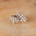 Diamond Pearl Stacked Hoops with pearls and sparkling gems rest on beige marble—ideal bridal jewelry or vintage-inspired wedding earrings for your special day.