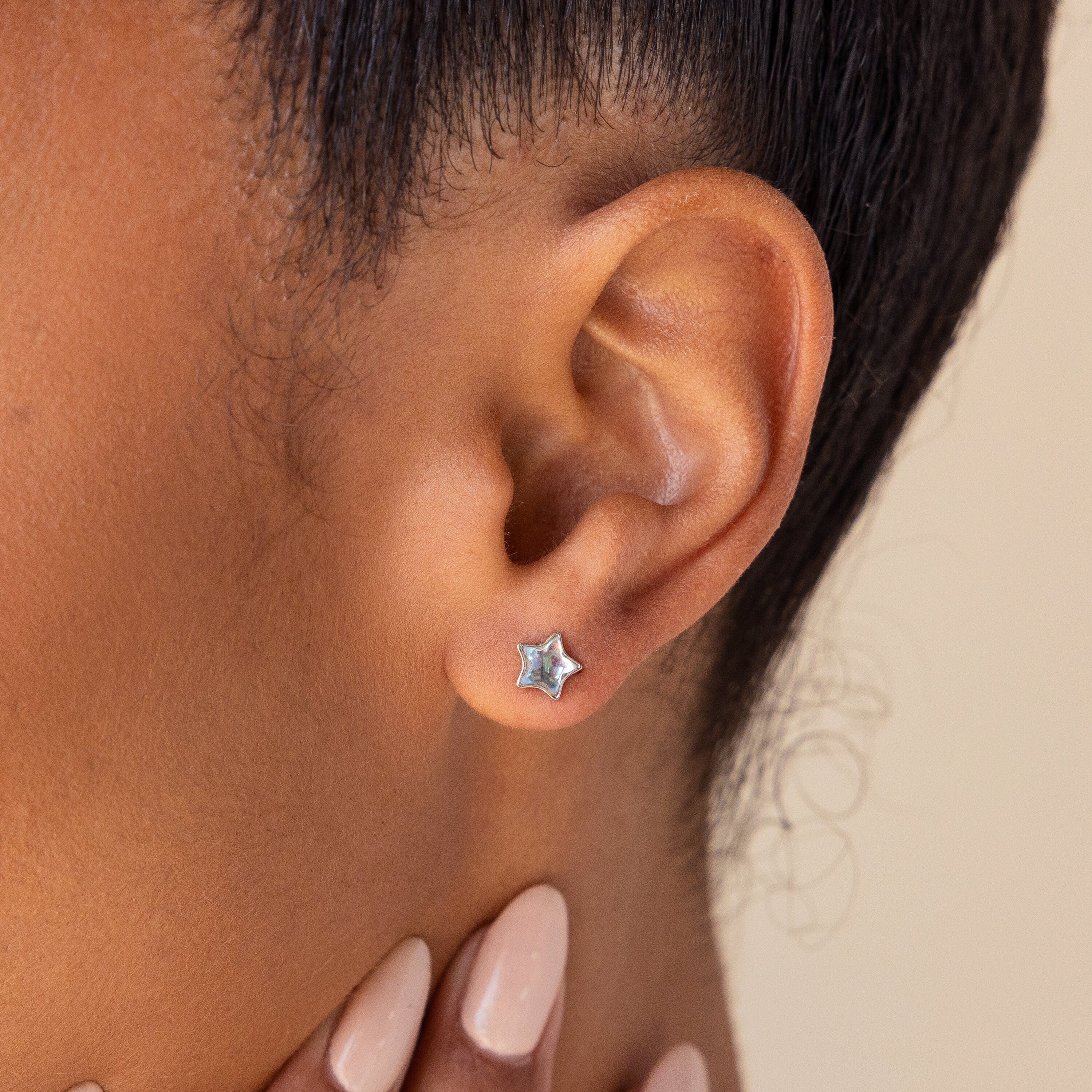 A close-up of a woman’s ear wearing Moonstone Star Studs, showcasing her love for celestial-inspired jewelry.
