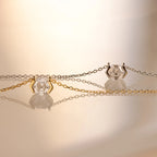Two delicate necklaces with hexagonal crystal pendants—one on a gold chain and one on a silver—offer modern elegance reminiscent of the Encased Hexagon Diamond Necklace in a half-bezel setting.
