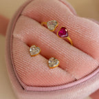 Bezel Heart Birthstone Studs with sparkling, heart-shaped stones are elegantly presented in a pink velvet heart-shaped jewelry box.