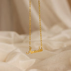 Luna Name Necklace in Paperclip Chain, personalized with "Amanda," shown on a soft beige fabric background.