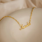 Luna Name Necklace in Paperclip Chain, personalized with "Amanda" in elegant cursive, is displayed on a smooth beige surface.
