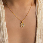 The Pave Pearl Compass Necklace graces the neck, paired with a cream textured v-neck top for a subtle touch of nautical charm.