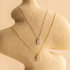 The Pave Pearl North Star Necklace adds celestial sparkle to a textured abstract beige mannequin, paired with a radiant gold Mother of Pearl pendant.
