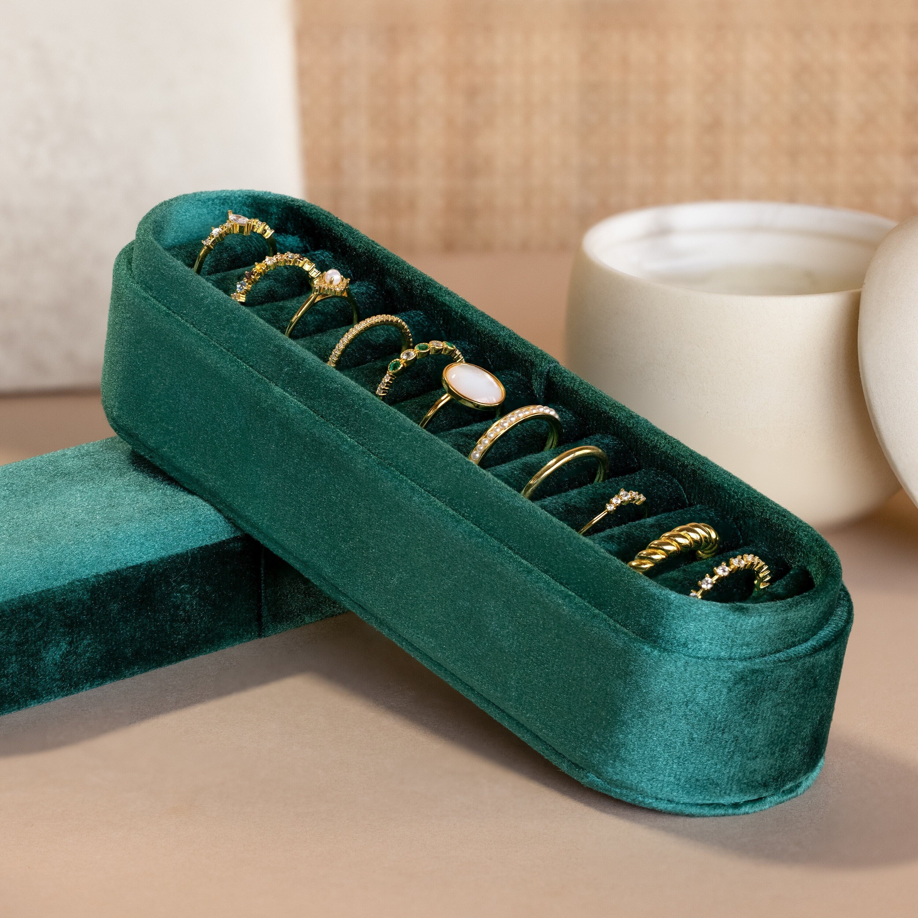 The Slim Velvet Ring Box showcases elegant gold rings, with a candle and ceramic bowl softly blurred in the background.