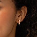 Close-up of a woman's ear wearing Beaded Pearl Huggies, featuring a modern design with delicate small pearls.