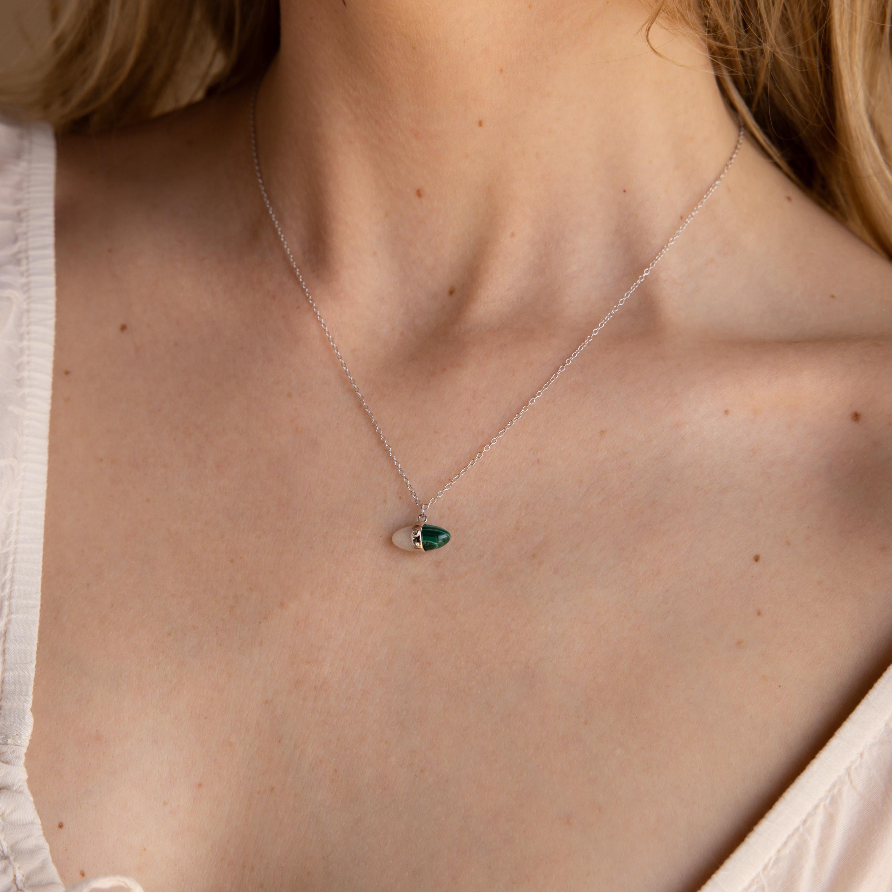 A close-up of a person wearing the Malachite & Moonstone Necklace, showcasing a dainty green and silver pendant—an elegant piece of healing gemstone jewelry.