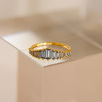 The Art Deco Aquamarine Ring features rectangular, light blue gemstones and is displayed on a clear surface, radiating vintage glamour.