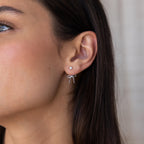 Close-up of a woman’s ear wearing the Pearl & Bow Ear Jackets in Sterling Silver, showcasing the elegant combination of a small pearl stud with a delicate silver bow accent.