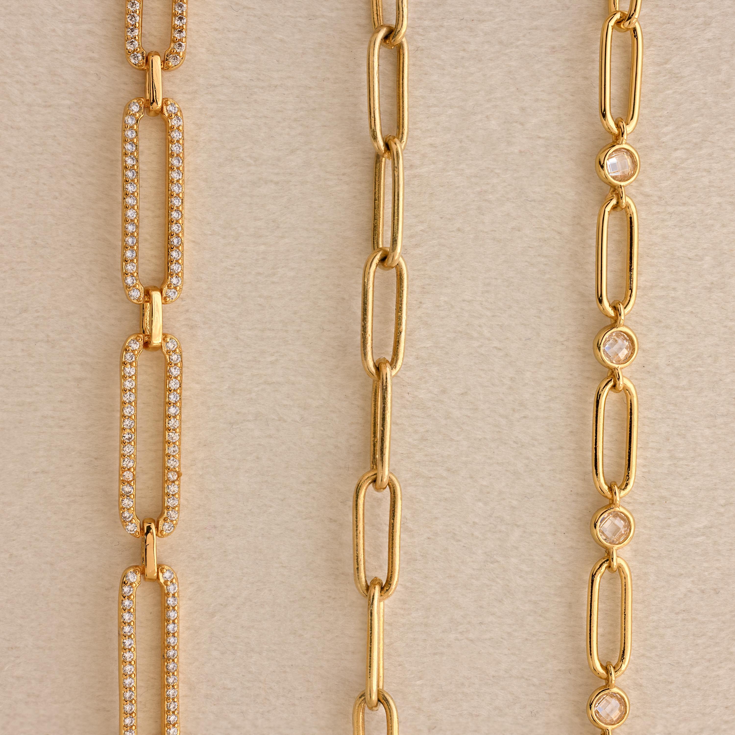 Three gold chain necklaces—a Pave Link Chain Necklace with sparkling diamonds, a plain chain, and one adorned with small round gems—are displayed on a neutral background.