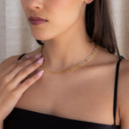 Woman wearing the Pave Link Chain Necklace with a black top, touching her collarbone with manicured fingers.
