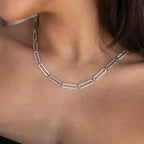 Close-up of a woman wearing the Pave Link Chain Necklace, featuring silver links with sparkling pave details on her bare neck.