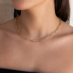 A woman wears the Pave Link Chain Necklace, featuring bold rectangular links, over a bare neckline.