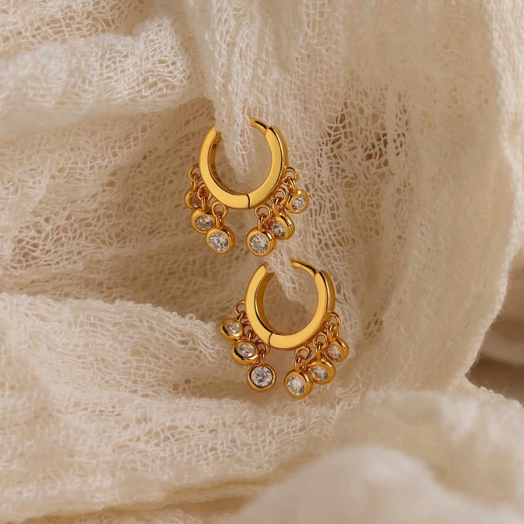 Chandelier Diamond Huggies showcased on textured cream-colored fabric.