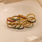 Eternity Marquise Birthstone Rings with colorful gemstones arranged in a circle on a white, translucent surface—each customizable for any birthstone, making it a thoughtful Christmas gift.