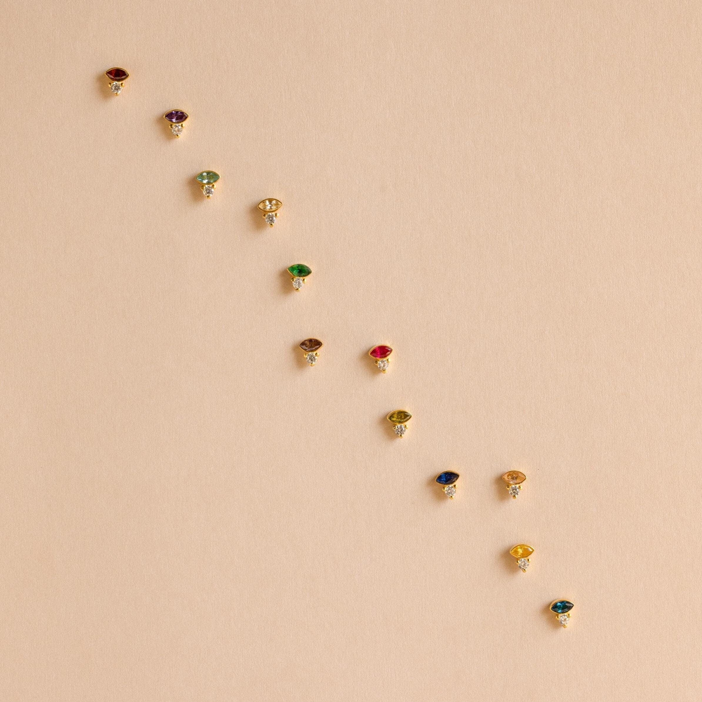 The Diamond Marquise Birthstone Studs feature a row of sparkling gemstones in an elegant marquise-cut design, perfect for adding shine to any outfit.