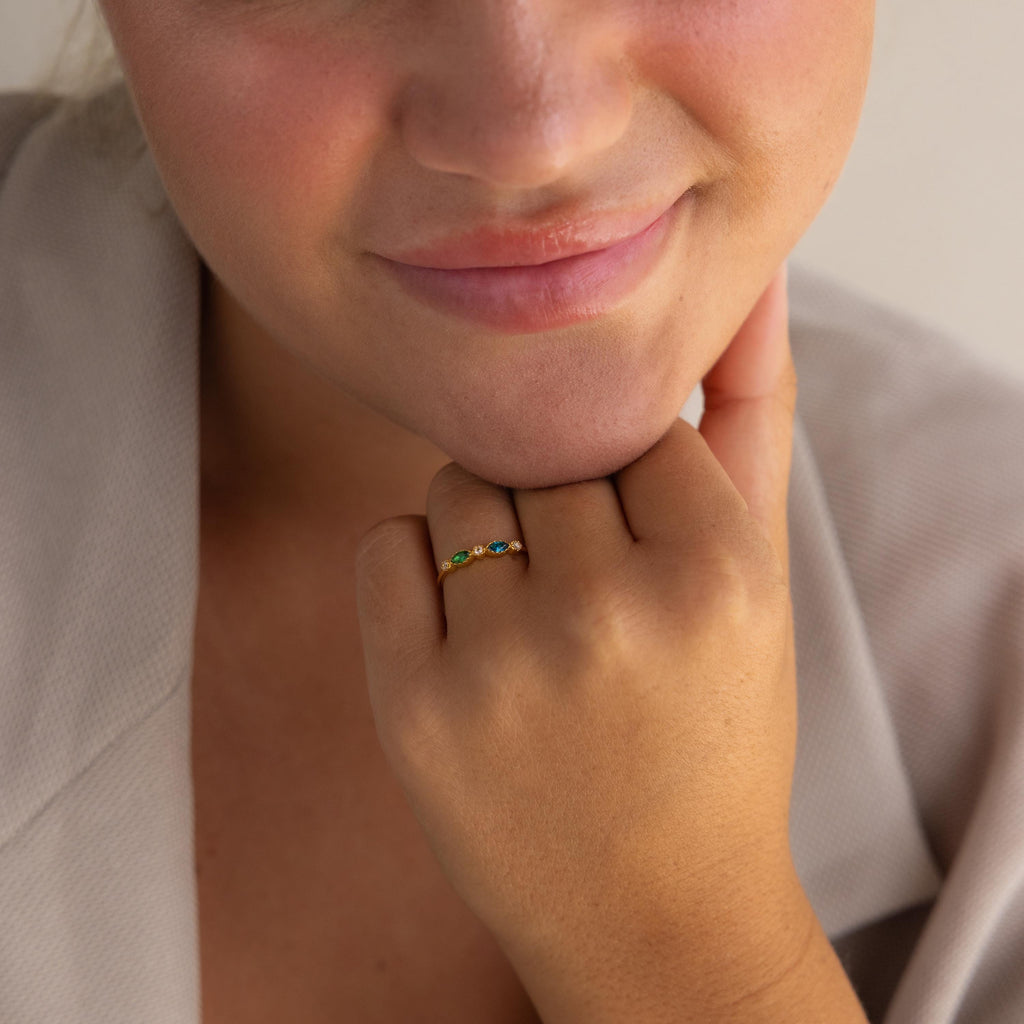 Close-up of a person smiling, showcasing the Cluster Marquise Birthstone Ring with colorful gemstones on their finger.