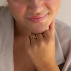 Close-up of a person smiling, showcasing the Cluster Marquise Birthstone Ring with colorful gemstones on their finger.