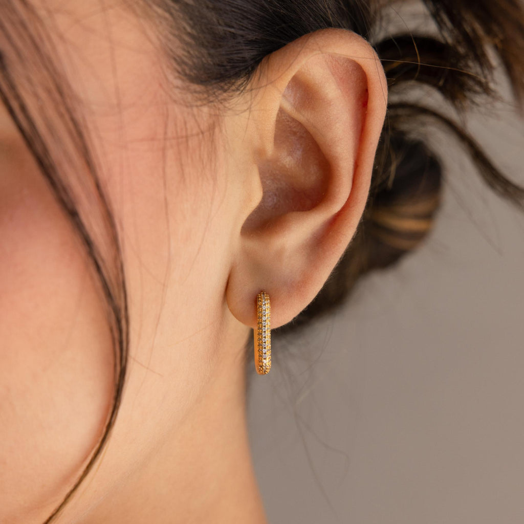 Close-up of a woman's ear wearing Chunky Pave Link Earrings, featuring geometric hoops with sparkling stones for a modern take on classic style.