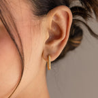 Close-up of a woman's ear wearing Chunky Pave Link Earrings, featuring geometric hoops with sparkling stones for a modern take on classic style.