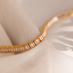 The Vertical Baguette Tennis Bracelet, featuring rectangular gemstones in an Art Deco style, is displayed on soft, light fabric under gentle lighting.