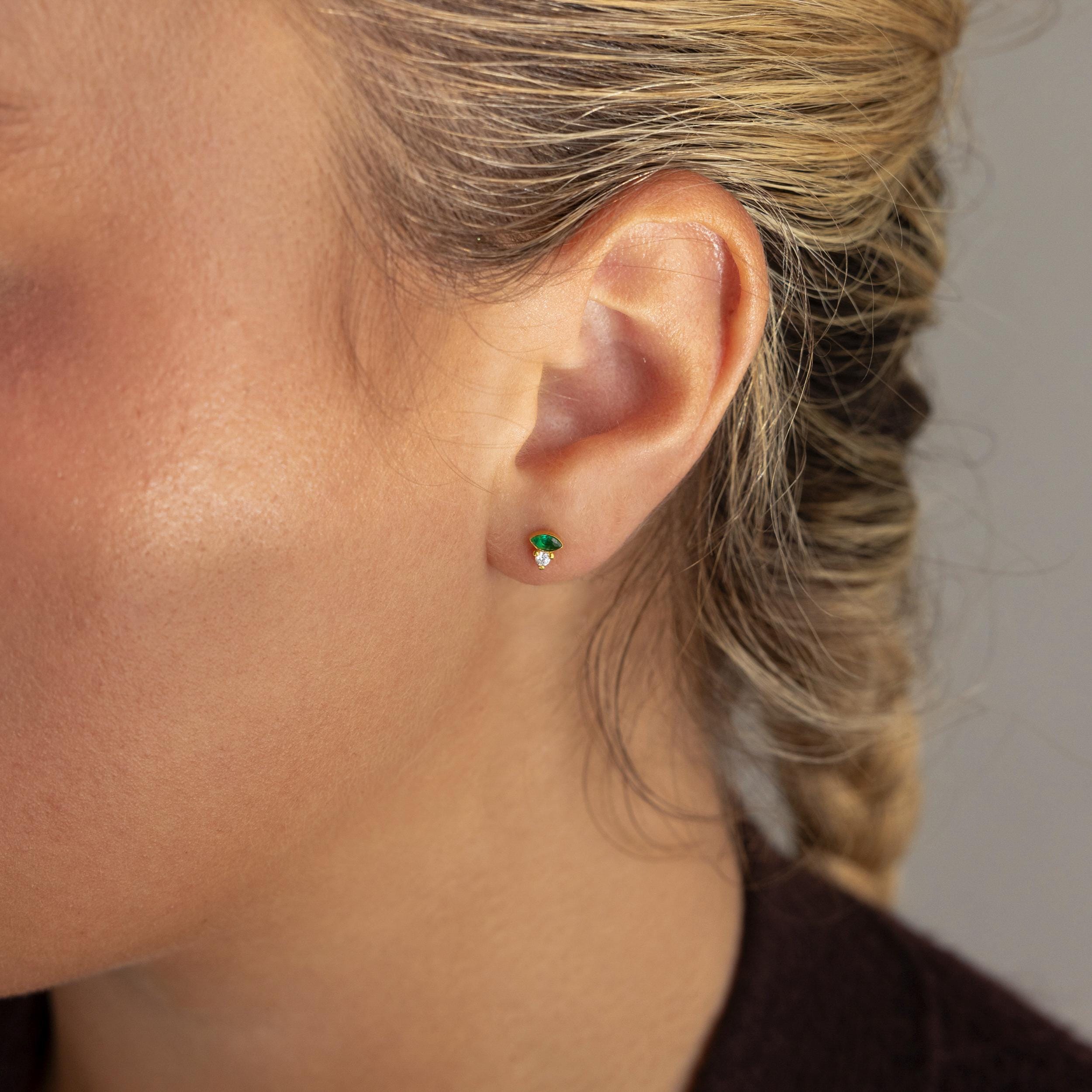 A close-up of a woman's ear wearing Diamond Marquise Birthstone Studs.