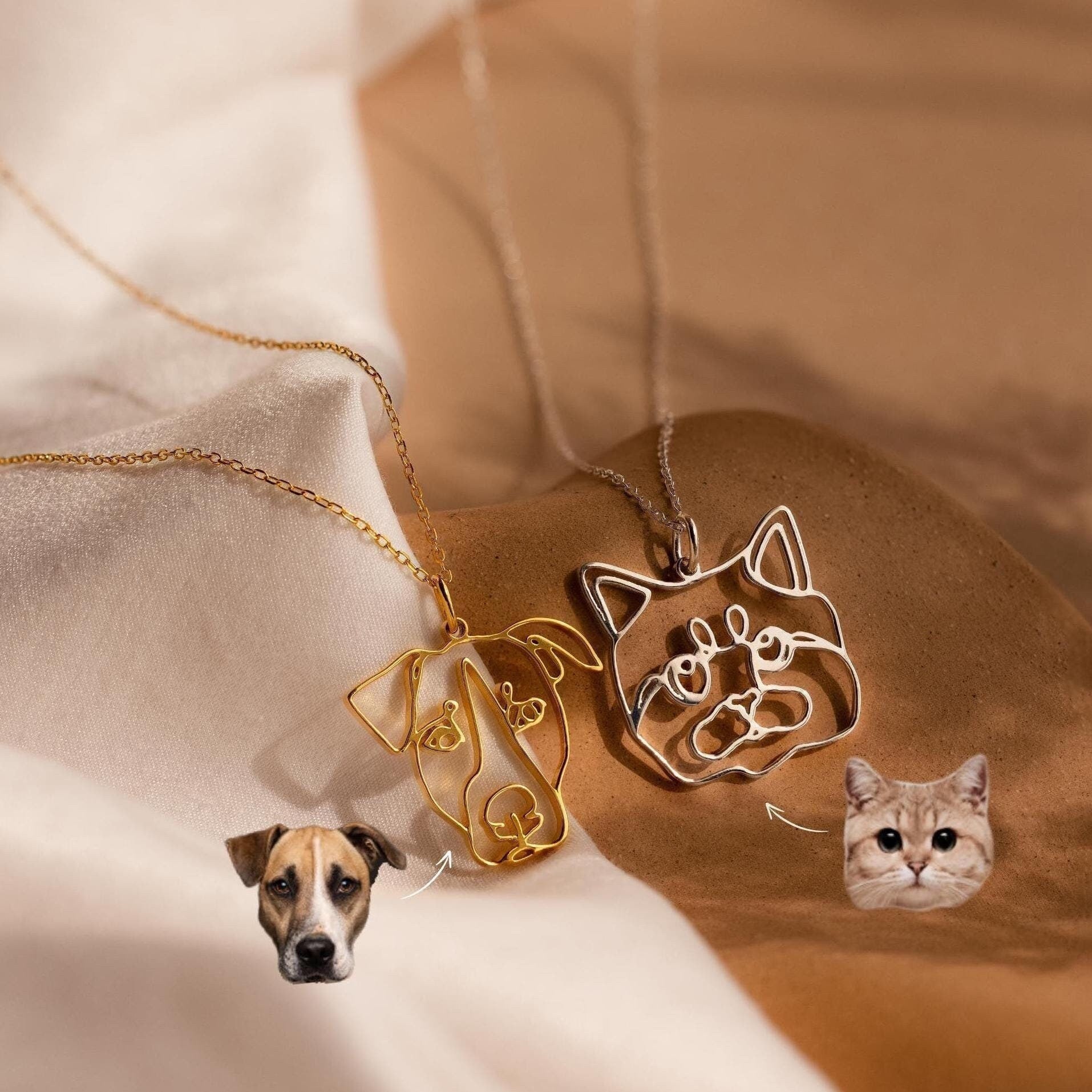 Two necklaces with gold dog and silver cat outline pendants, shown with matching emojis below. The Custom Pet Line Art Necklace is a charming choice for personalized pet jewelry lovers.