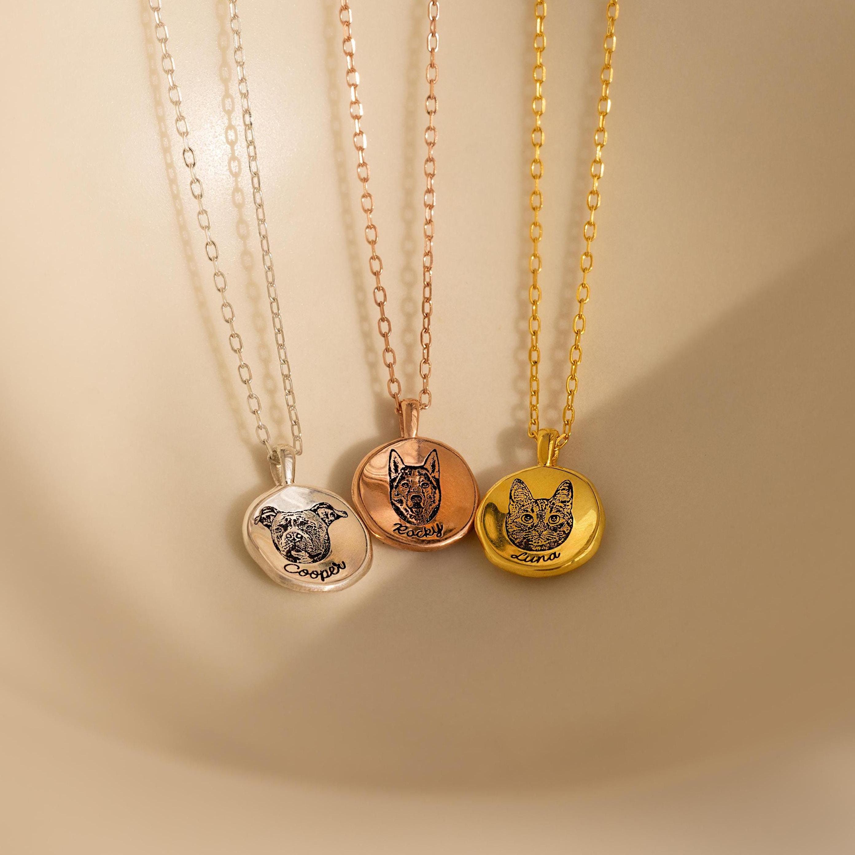 Three Pet Portrait Coin Necklaces in silver, rose gold, and gold rest on delicate chains against a beige background—a beautiful piece of pet memorial jewelry.