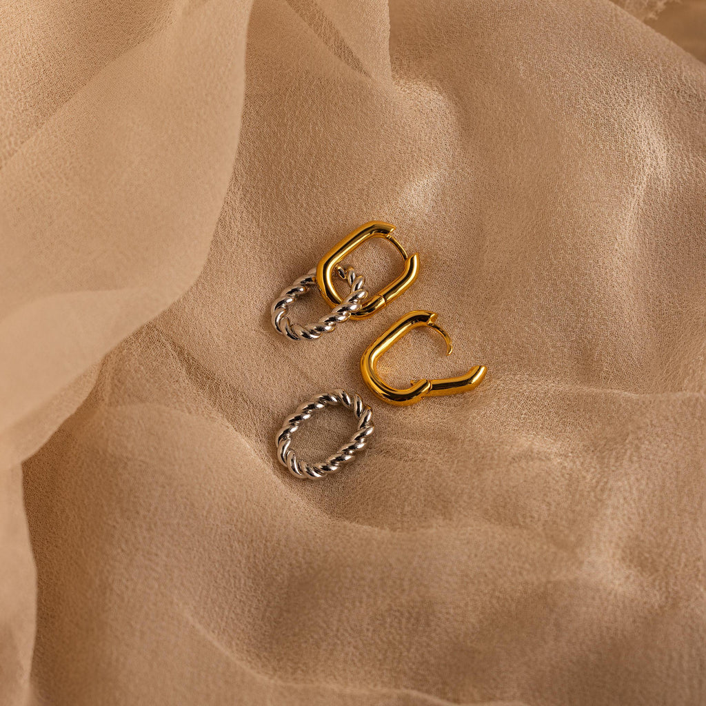 Mixed Metal Link Hoops with twisted details are displayed on beige sheer fabric, showcasing the elegance of these gold and silver earrings.