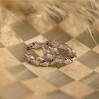 Inside Out Pear Diamond Hoops featuring multiple teardrop-shaped clear stones, ideal as a bridesmaid gift, displayed on a checkered beige and cream surface.