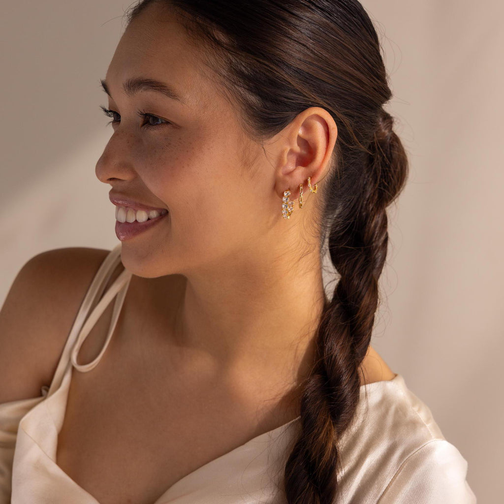 Smiling woman with braided hair wears Inside Out Heart Diamond Hoops and a satin off-shoulder top.