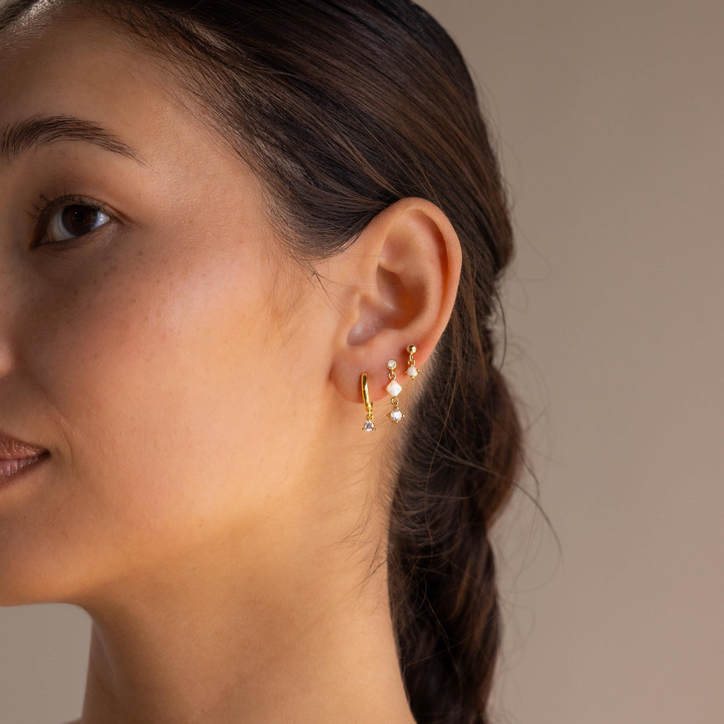 A woman wearing elegant Opal & Diamond Drop Studs.