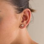 Close-up of a woman's ear wearing Art Deco Studs—small, gold fan-shaped earrings with tiny gemstones that add vintage glamour.