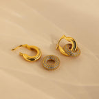 Duo Pave Link Hoops with removable round pavé crystal charms rest elegantly on a beige surface—ideal for anyone who loves bold hoops with sparkling details.