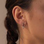 Close-up of a woman's ear wearing Link Drop Studs—a small silver hoop featuring an elegant chain link drop detail.