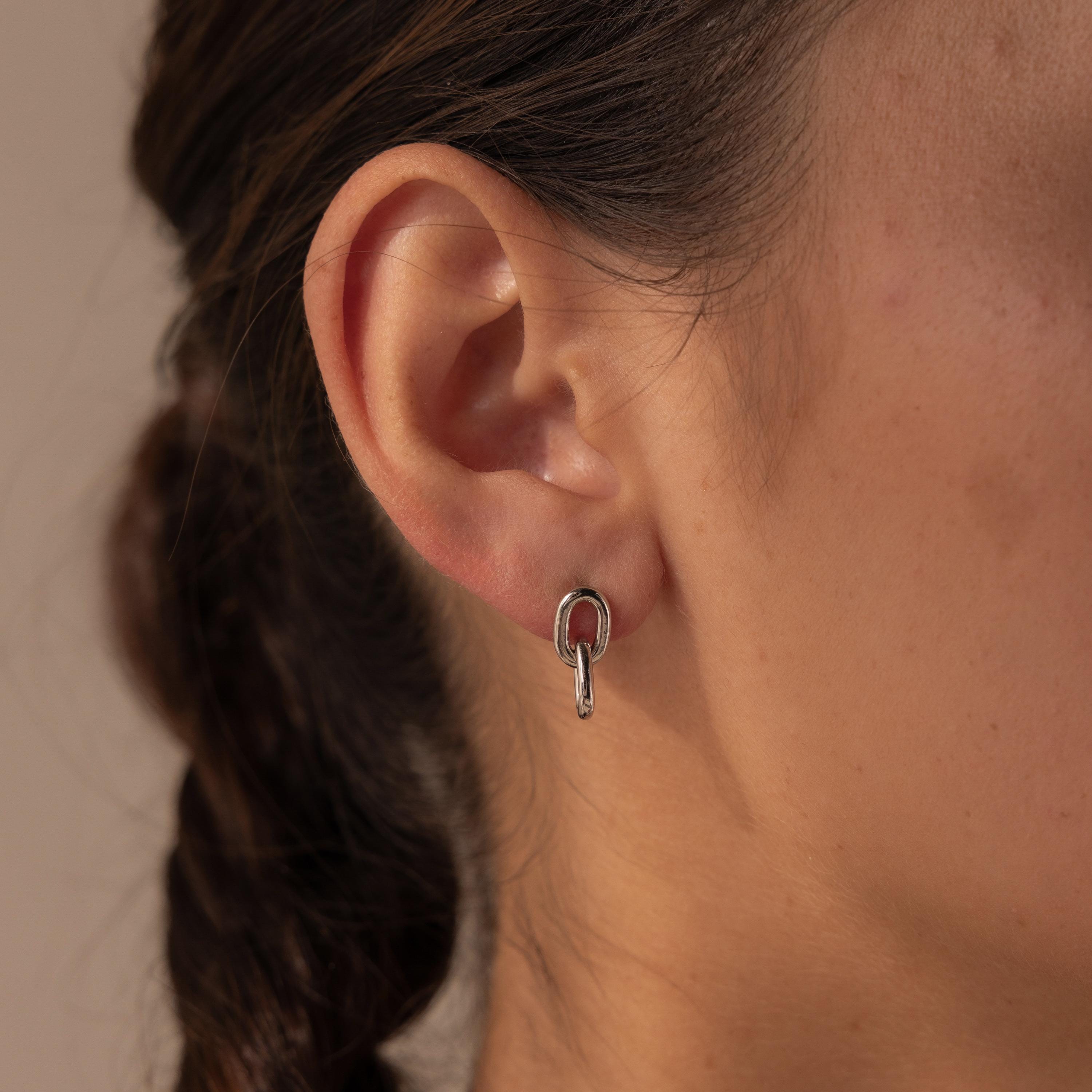 Close-up of a woman's ear wearing Link Drop Studs—a small silver hoop featuring an elegant chain link drop detail.